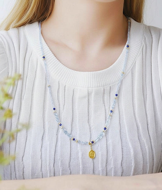 Necklace with a pendant worn by a person, with 'Amy's Garden' branding.
