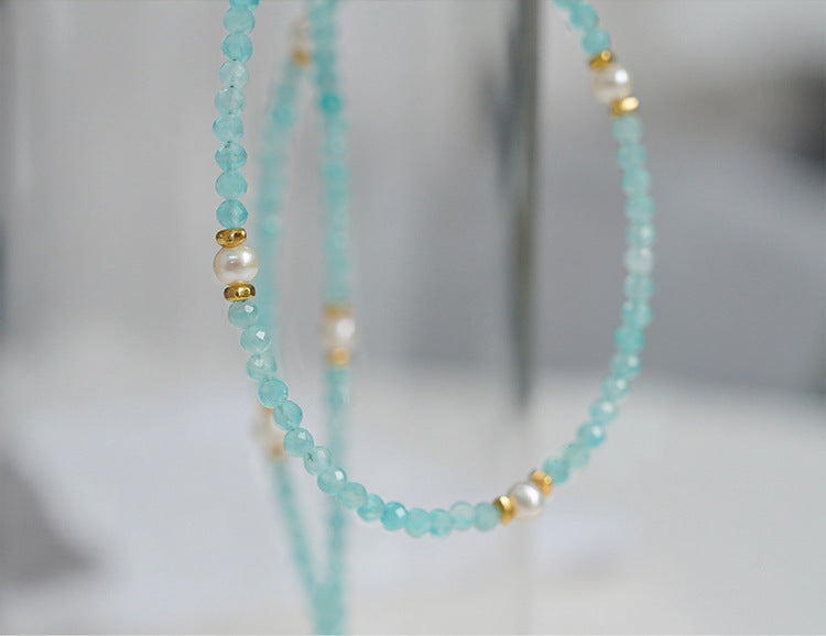 Beaded necklace with turquoise beads and gold accents on a blurred background