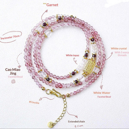 Pink beaded necklace with gold accents on a white background