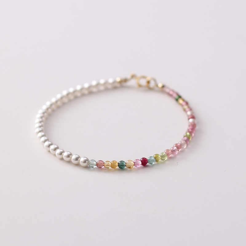 A bracelet with multicolor tourmaline and white pearl beads, featuring a gold-plated clasp.