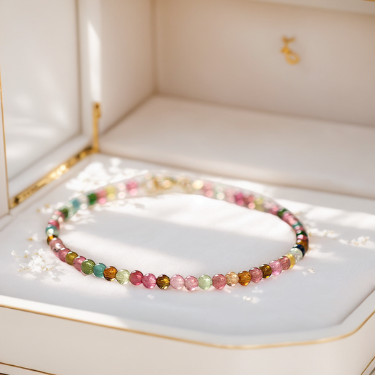 A multicolor tourmaline crystal bracelet displayed in an open jewelry box, highlighting the vibrant hues of the beads.