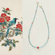 Beaded necklace with red and blue accents on a white background, next to a traditional Chinese painting of a bird and flowers.