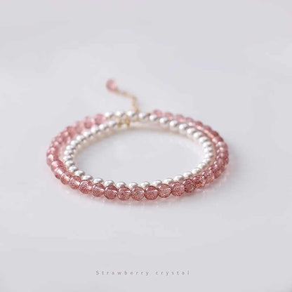 A double-layered bracelet with alternating pink strawberry crystal beads and white pearl beads, displayed against a white background.