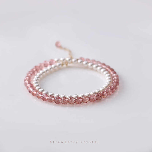 A double-layered bracelet with alternating pink strawberry crystal beads and white pearl beads, displayed against a white background.