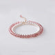 A double-layered bracelet with alternating pink strawberry crystal beads and white pearl beads, displayed against a white background.