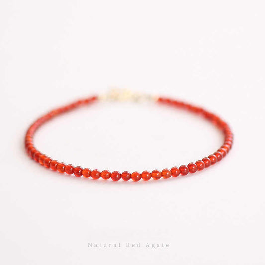 A handcrafted bracelet made from natural carnelian gemstones with a smooth, polished finish. The bracelet is primarily orange in color, showcasing the vibrant hue of the carnelian beads.