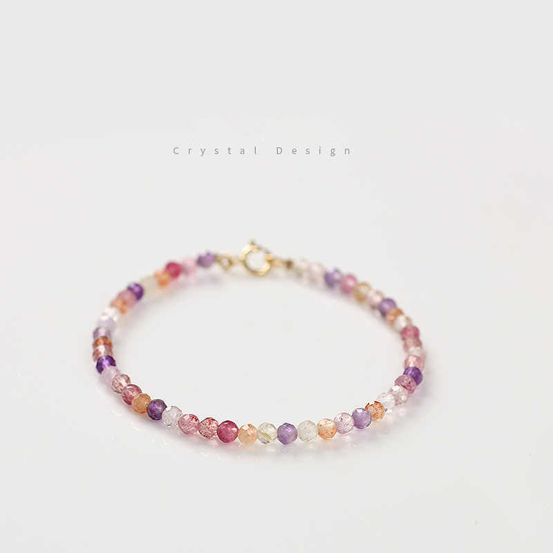 A Super Seven Crystal Bracelet with faceted beads in multiple colors and a gold-plated clasp, displayed against a white background.