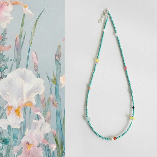 Colorful beaded necklace on a light gray background with floral illustration.