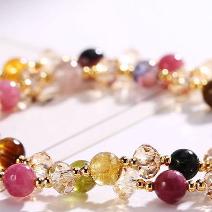 Colorful beaded bracelet with gold accents on a white background