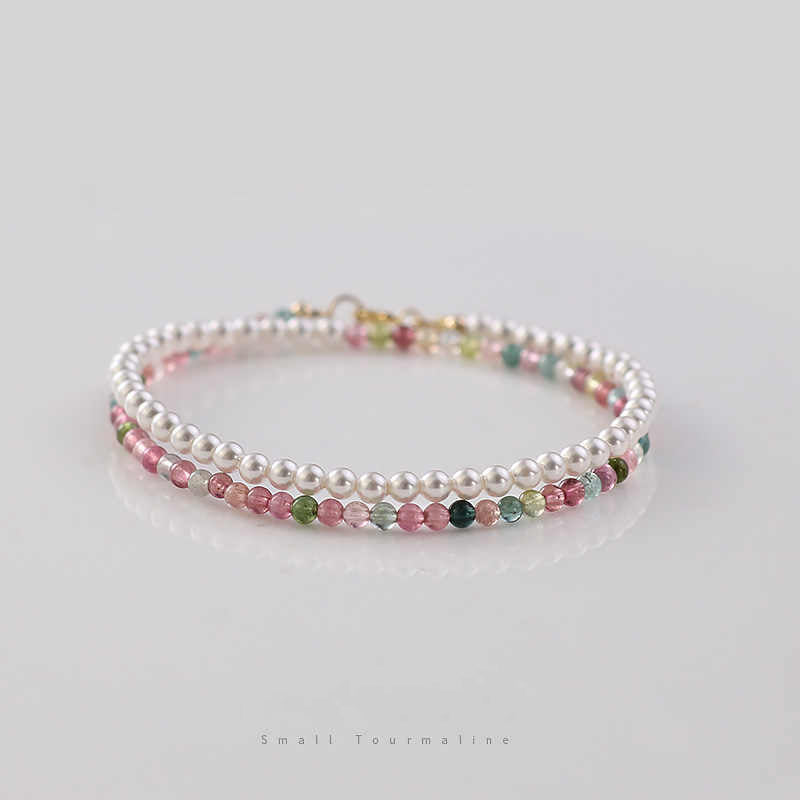 Beaded bracelets with pink, green, and white beads on a light background
