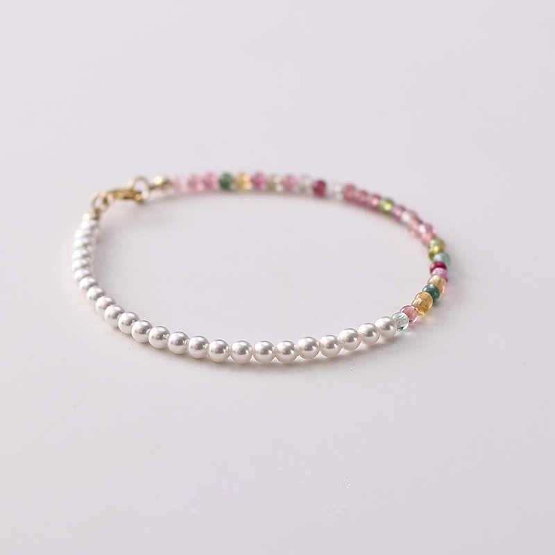 Beaded bracelet with white pearls and multicolored beads on a white background