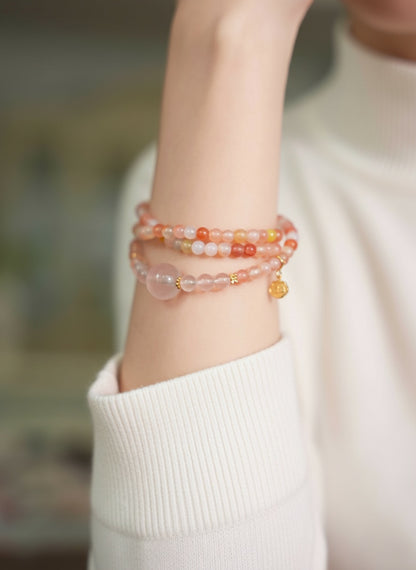 Close-up of a wrist wearing two beaded bracelets on a blurred background