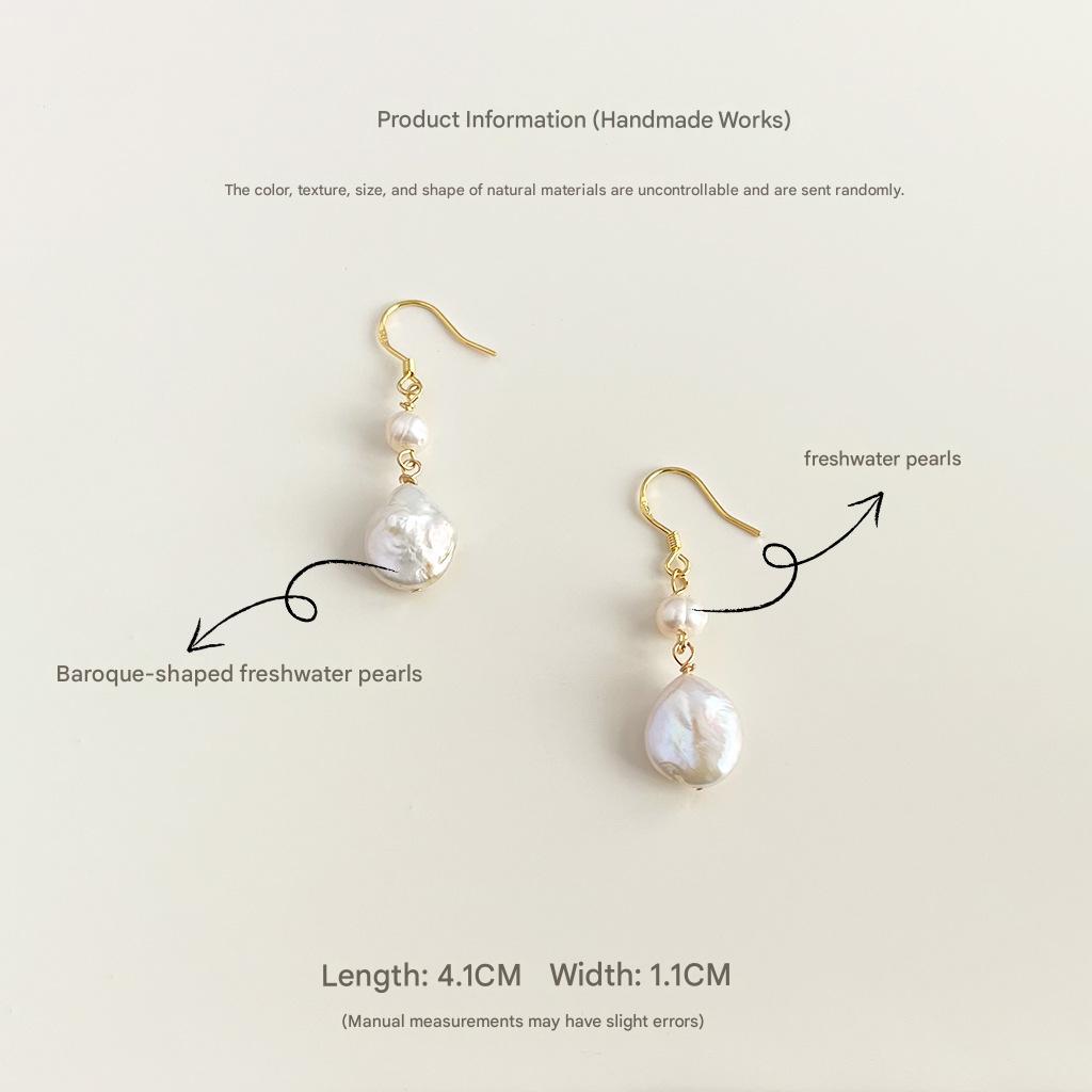Pair of pearl earrings with gold hooks on a light beige background
