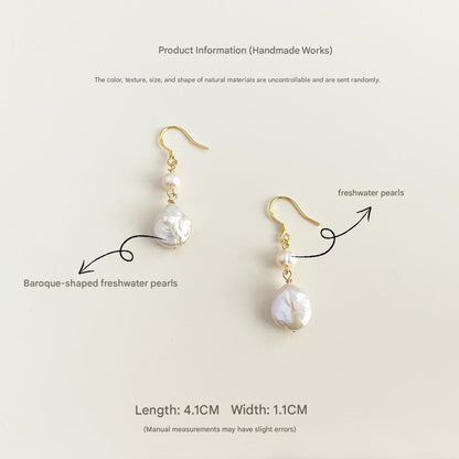Pair of pearl earrings with gold hooks on a light beige background