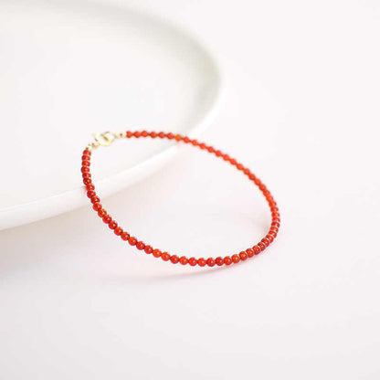 Red beaded bracelet on a light background