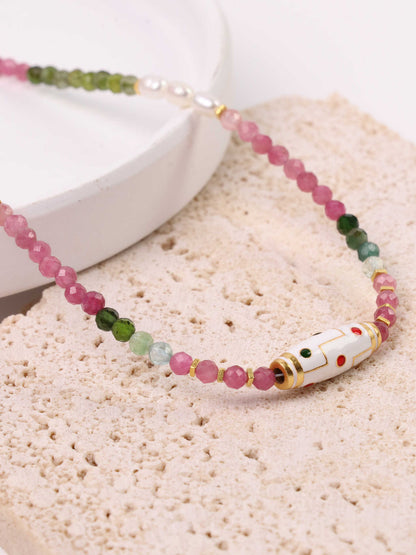 Beaded necklace with colorful beads on a textured surface