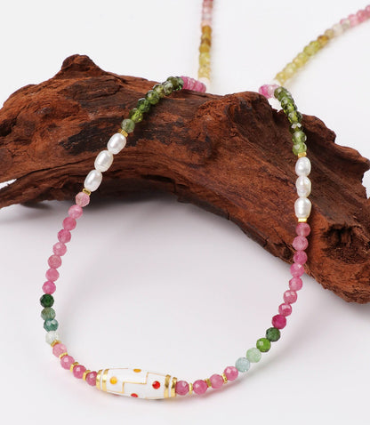 Necklace with multicolored beads on a wooden log