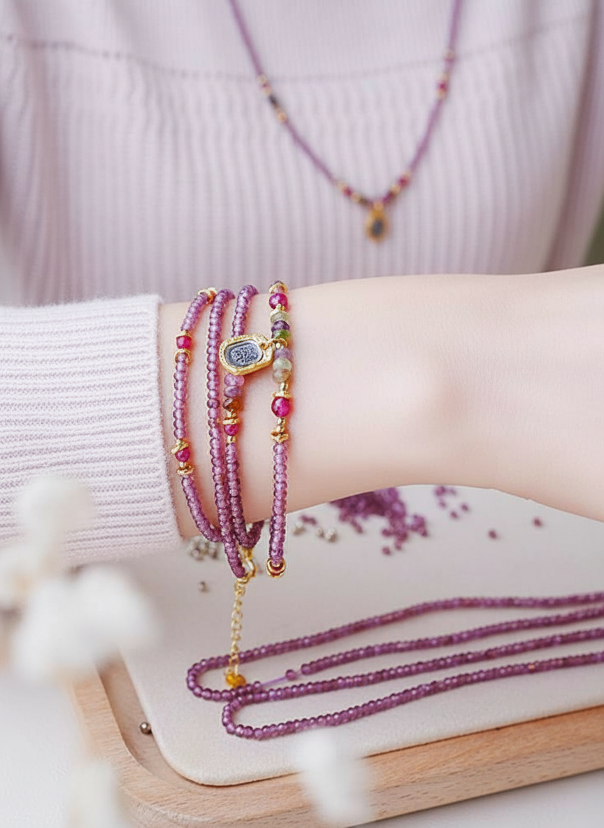 Close-up of a wrist with multiple beaded bracelets on a light background
