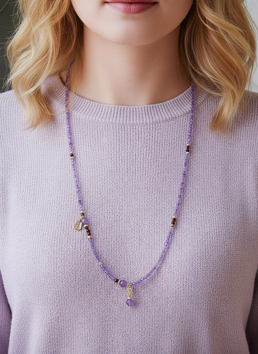 Person wearing a long purple beaded necklace against a neutral background