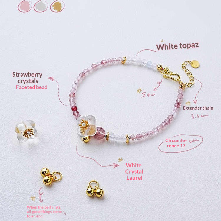 Bracelet with strawberry crystals, white topaz, and gold accents on a light background