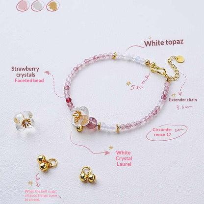 Bracelet with strawberry crystals, white topaz, and gold accents on a light background