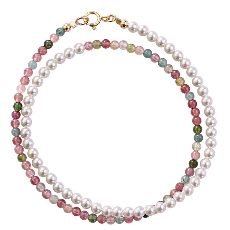 Necklace with pearls and multicolored gemstones on a white background