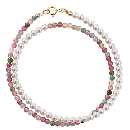 Necklace with pearls and multicolored gemstones on a white background