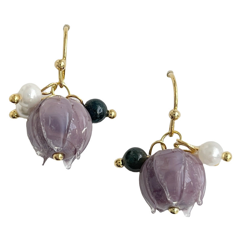 Pair of earrings with purple and black beads on a white background