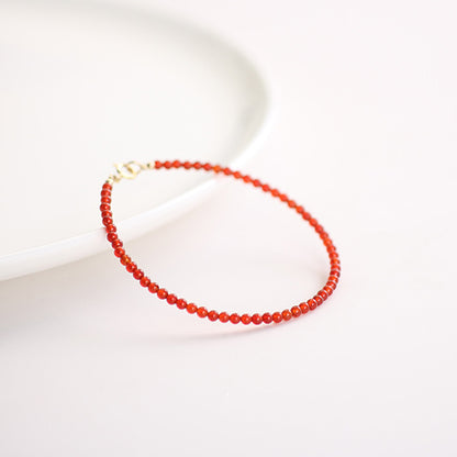 Red beaded bracelet on a light background