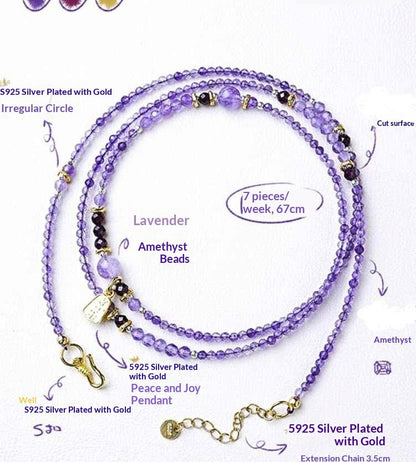 Purple beaded necklace with gold accents on a white background
