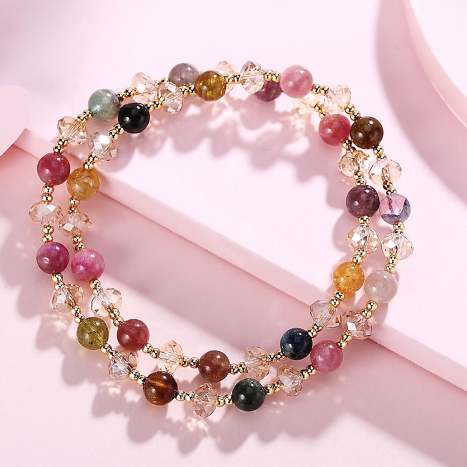 Multicolored beaded bracelet on a pink surface