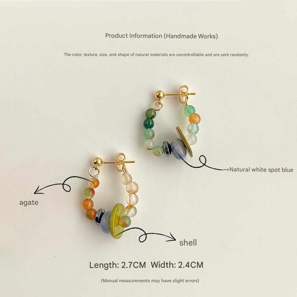 Pair of beaded earrings with gold accents on a light beige background