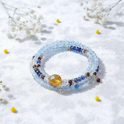 Beaded bracelet with colorful stones on a white background with small yellow flowers