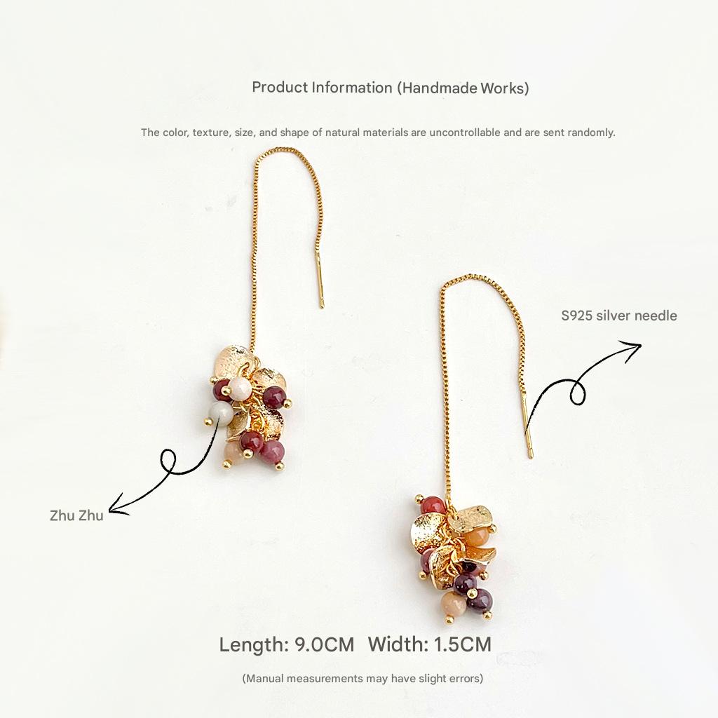 Gold earrings with beads on a white background, showing product information.