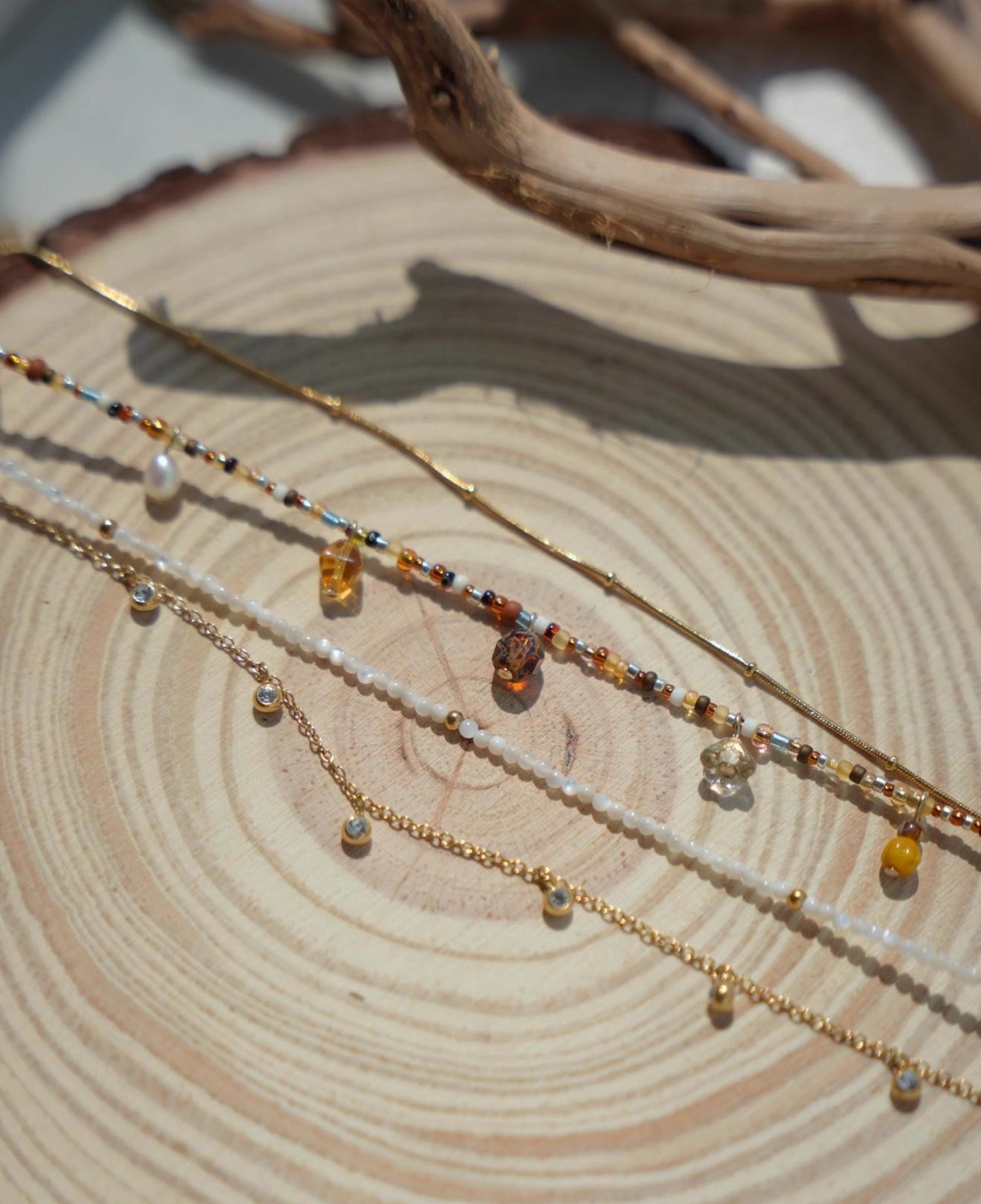 Three beaded necklaces on a wooden surface