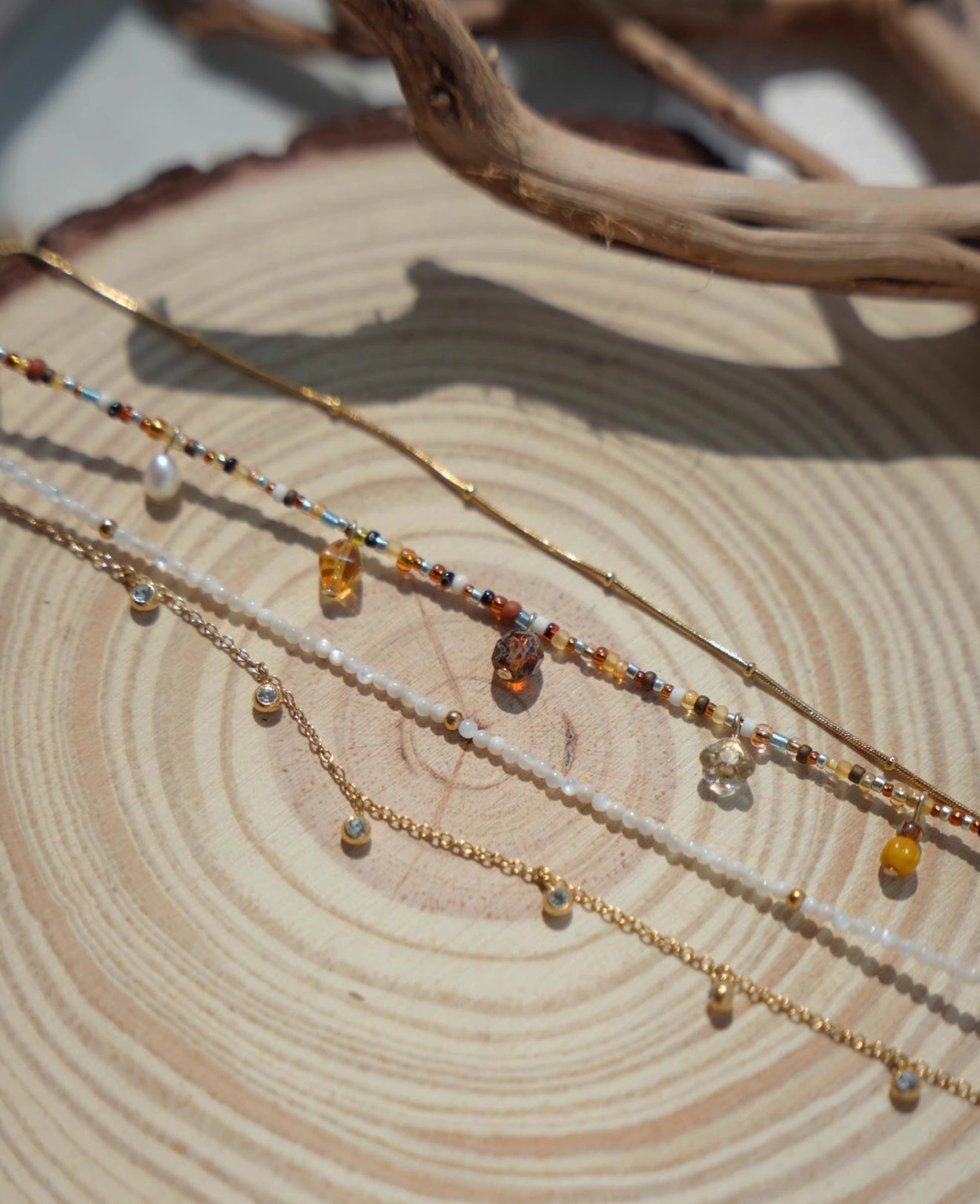 Three beaded necklaces on a wooden surface
