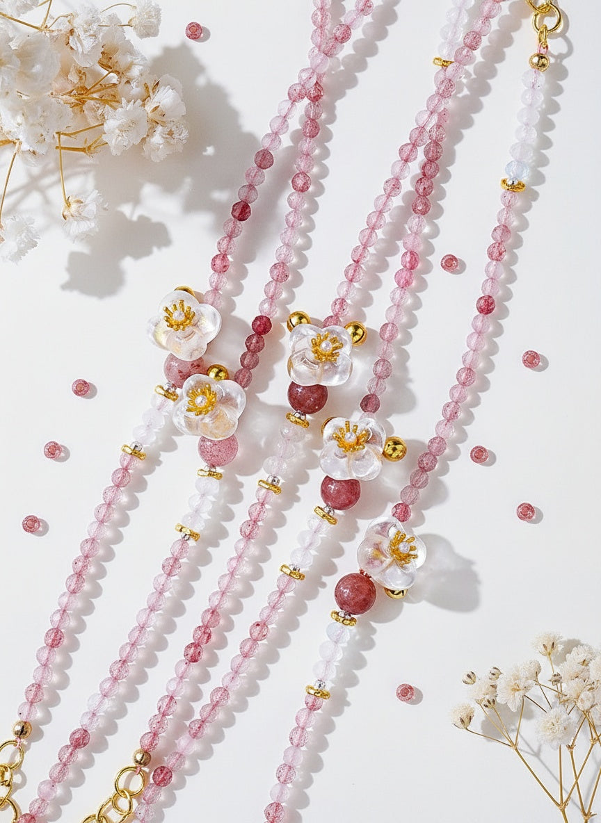 Beaded necklaces with floral pendants on a light background