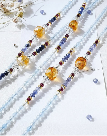 Colorful beaded strands on a white background with dried flowers.