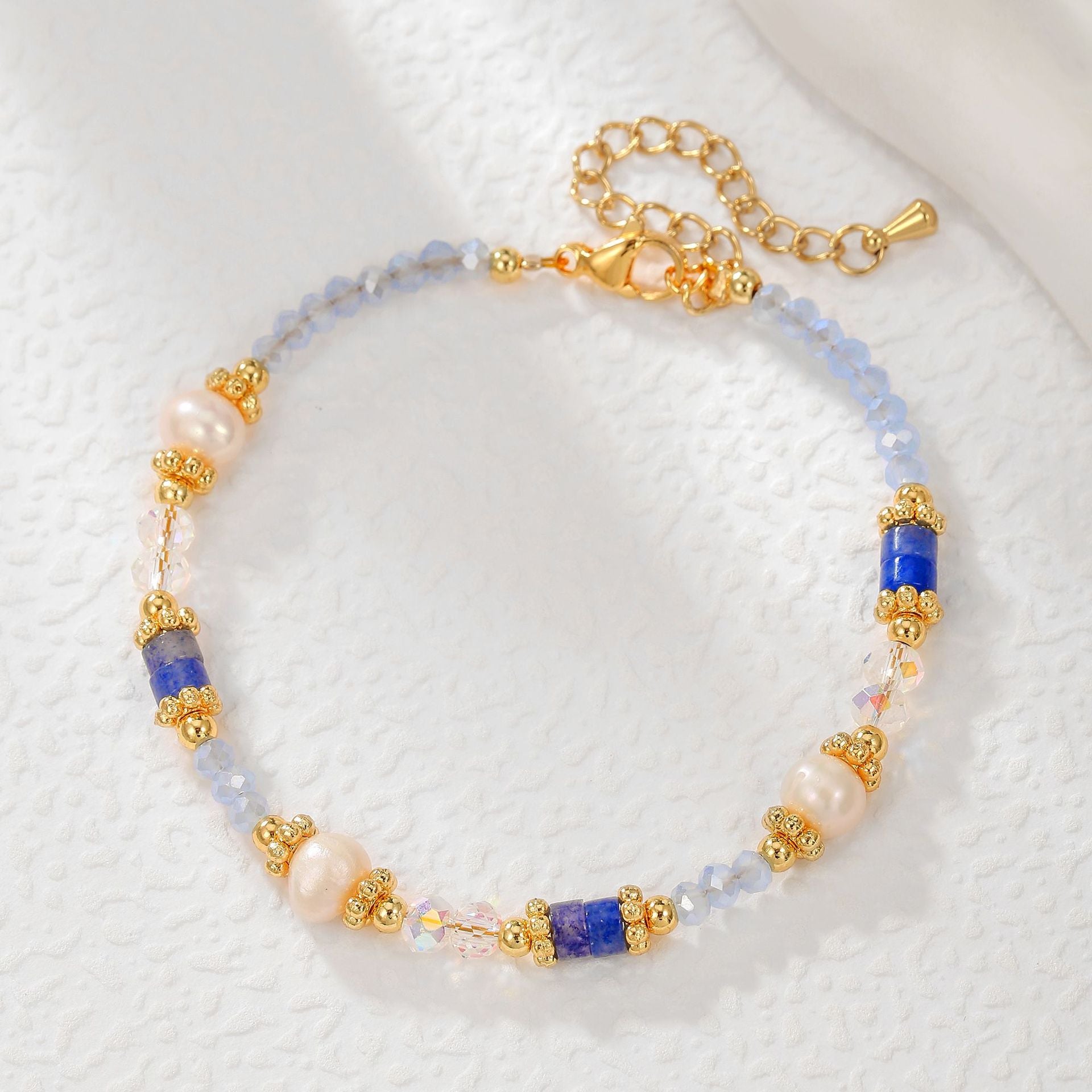 Beaded bracelet with gold accents on a textured white surface
