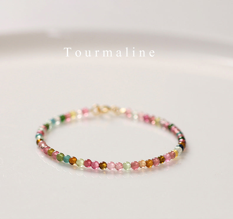 Multicolored beaded bracelet on a light background with 'Tourmaline' text.