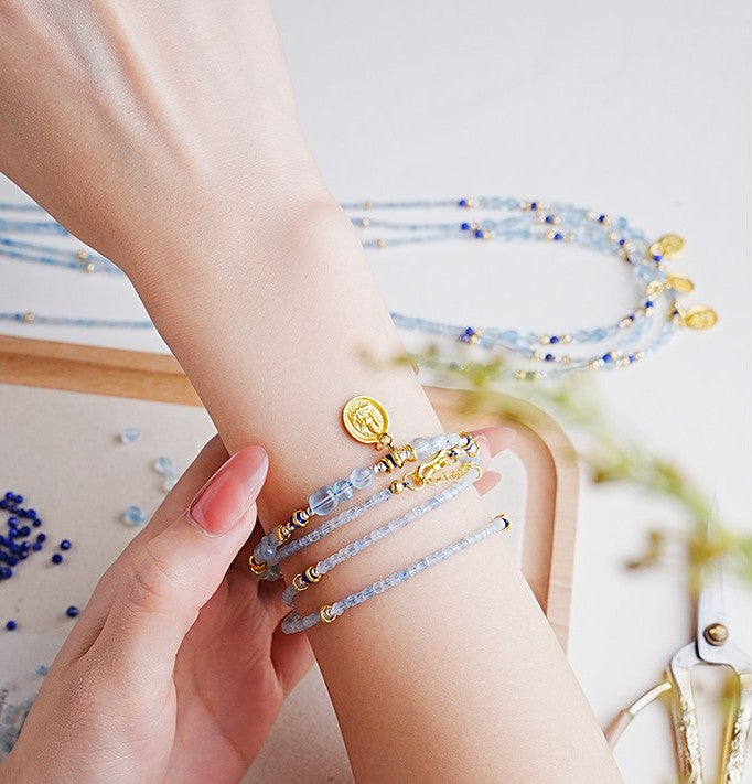 Close-up of a wrist wearing multiple beaded bracelets with gold accents.
