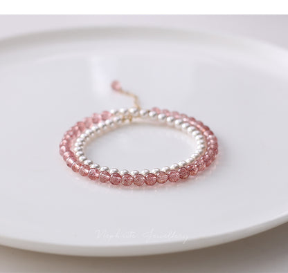 Two beaded bracelets, one pink and one silver, on a white plate.
