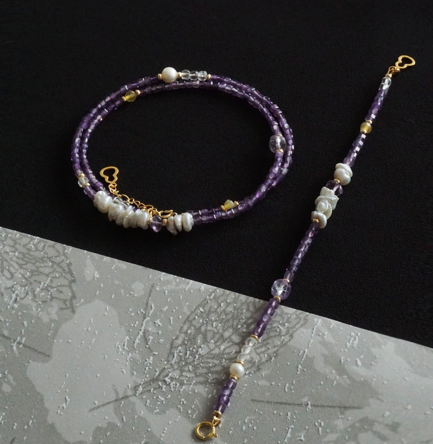 Purple beaded necklace with gold accents on a black and gray gradient background