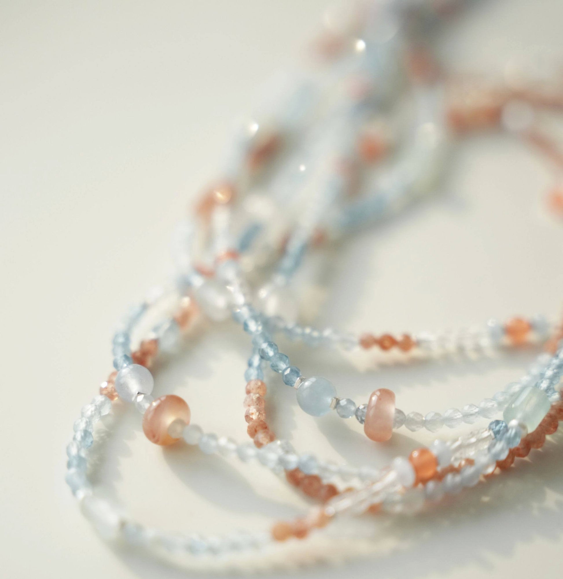 Close-up of a beaded necklace with multicolor beads on a light background