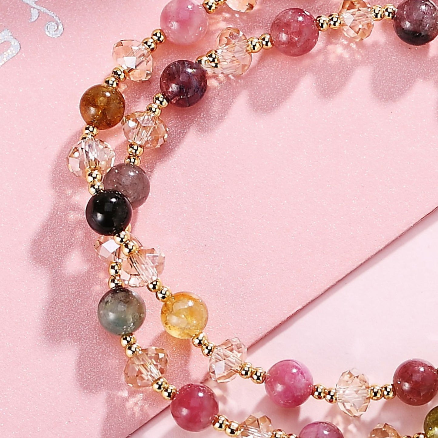 Multicolored beaded necklace on a pink background