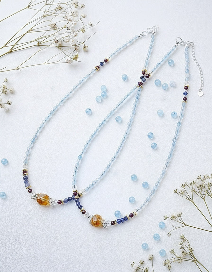 Beaded necklace with multicolored beads on a white background with dried flowers.