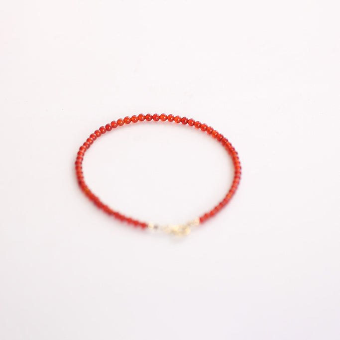 Red beaded bracelet on a white background