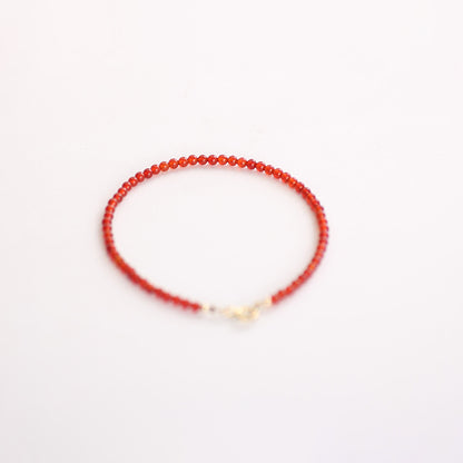 Red beaded bracelet on a white background