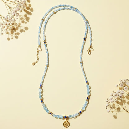 Beaded necklace with a pendant on a beige background with dried flowers