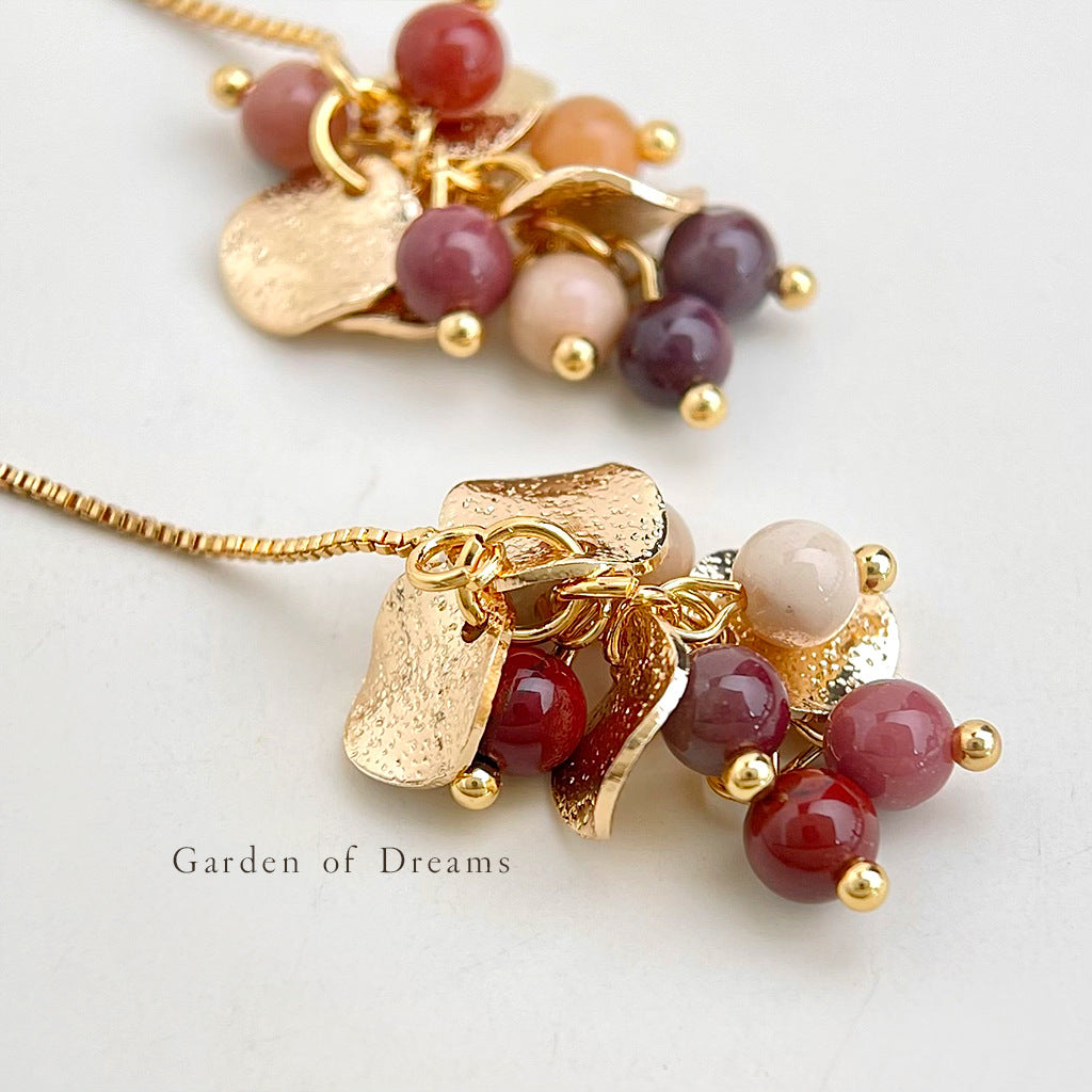 Gold necklace with colorful beads on a light background
